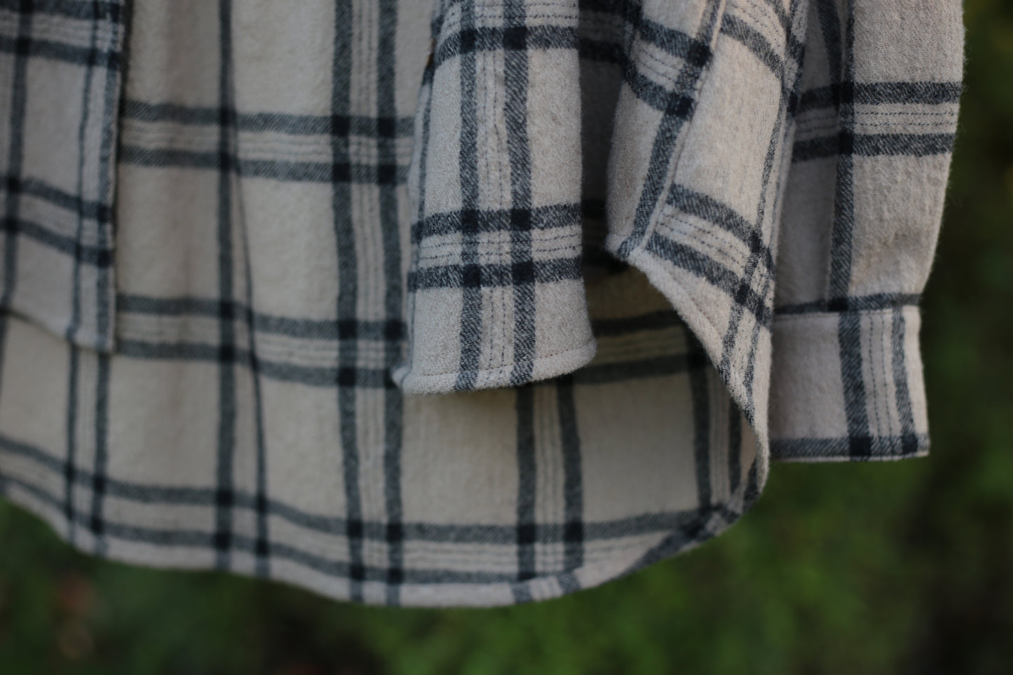 Close-up of a plaid shirt with a blurred green background